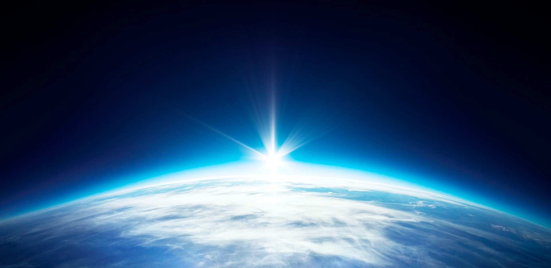 真っ黒な宇宙を背景に、鮮やかな青と白い雲が広がる、地球の図。